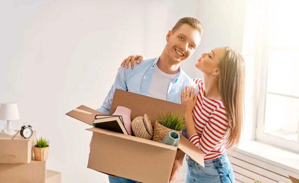 Couple holding a moving box while planning an interstate move.