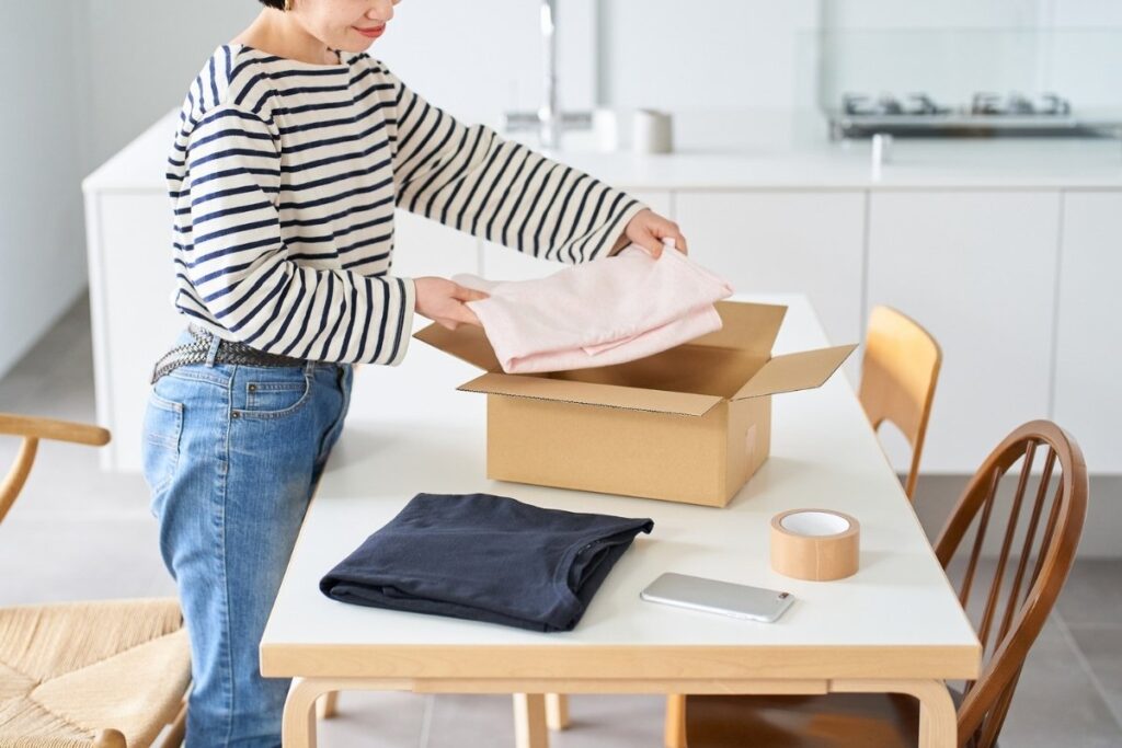 Folding clothes and packing them into a box at home.