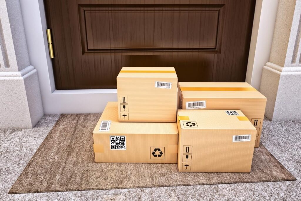 Cardboard boxes filled with glasses stacked at a front door.