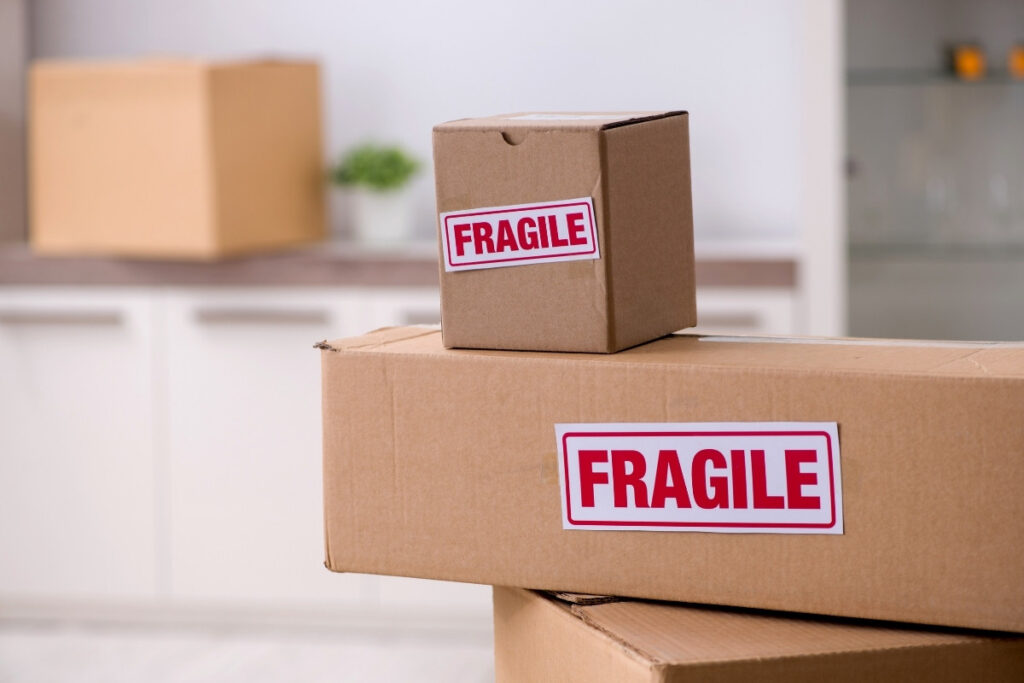 Fragile-labelled boxes stacked indoors.